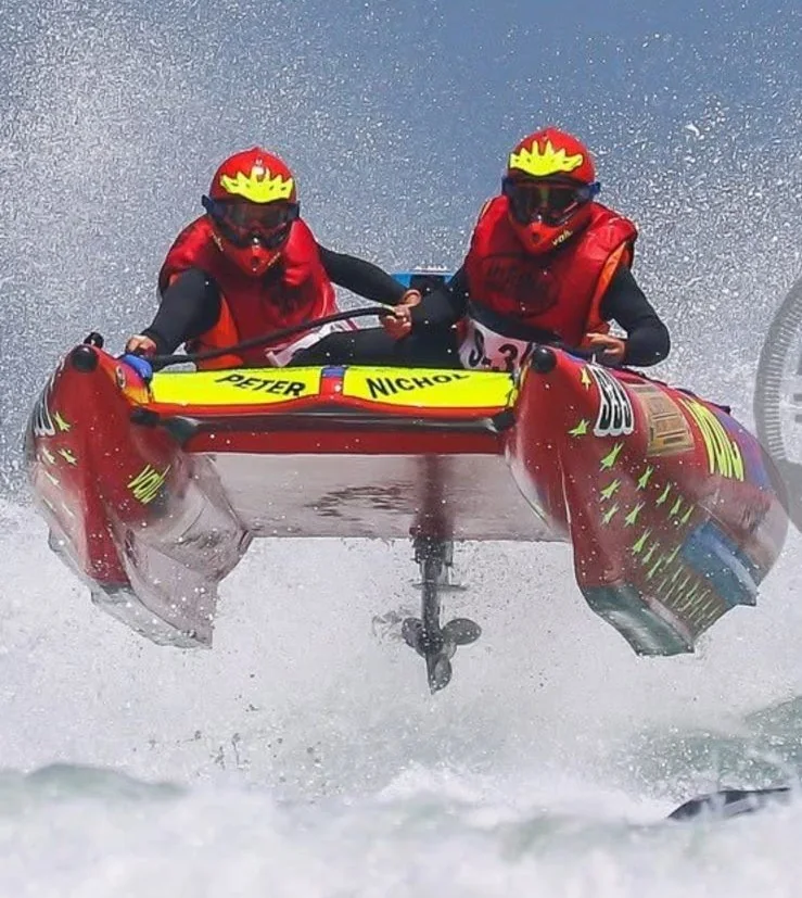 Peter and his co-pilot airborne in a red inflatable racing boat